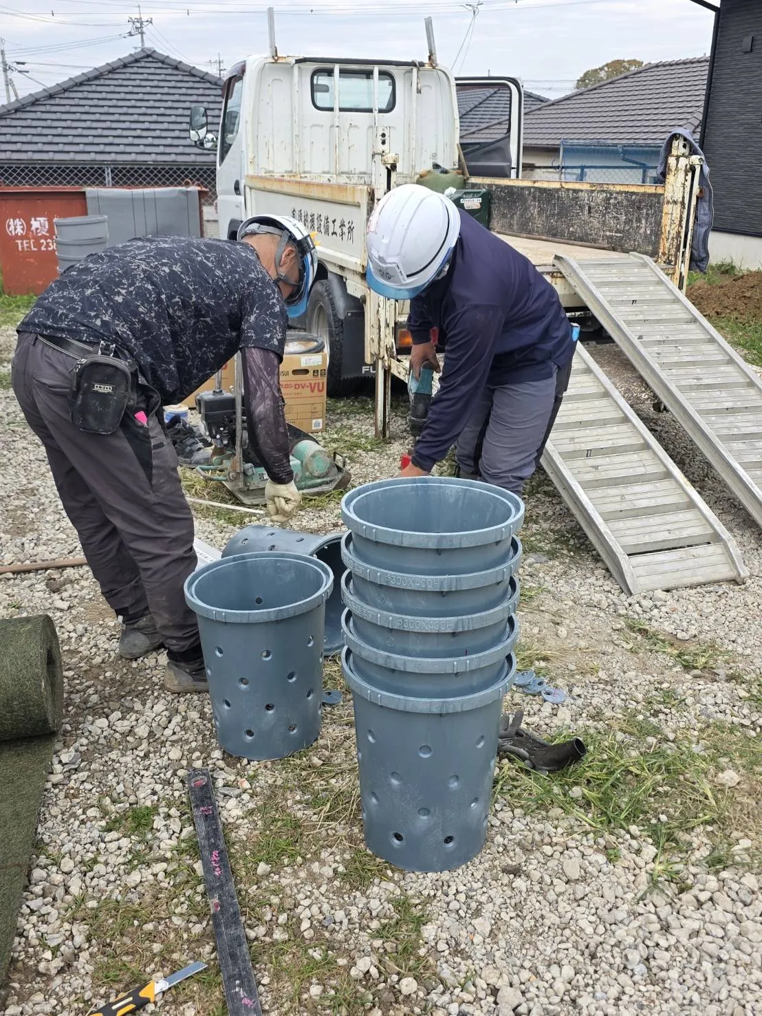 資材の納品を確認する須納瀬設備工業所のスタッフとトラック